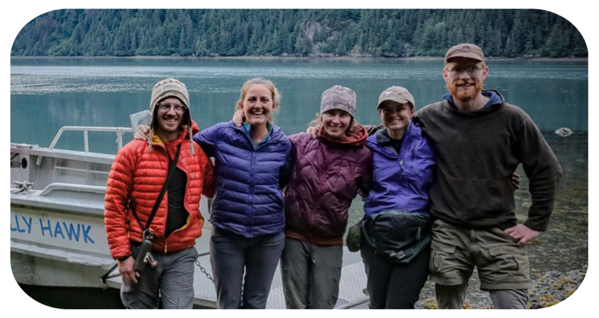 a group of people standing in front of a body of water