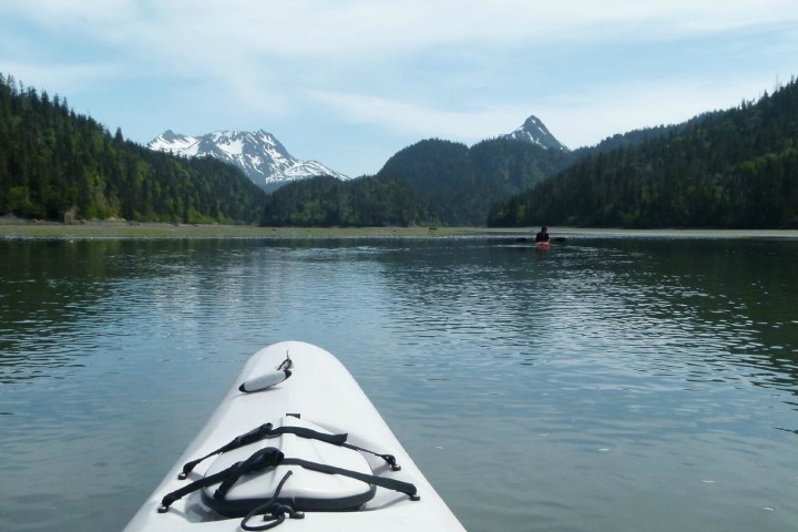 a small boat in a body of water with a mountain in the background