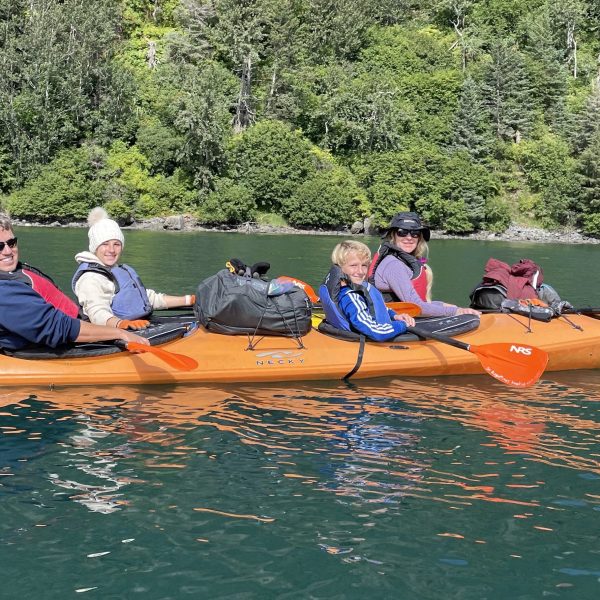 a group of people rowing a boat in the water